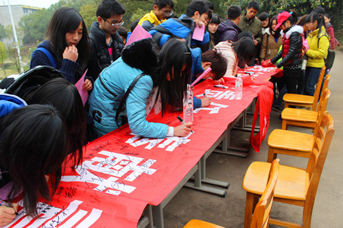 同学们踊跃的在横幅上签名。